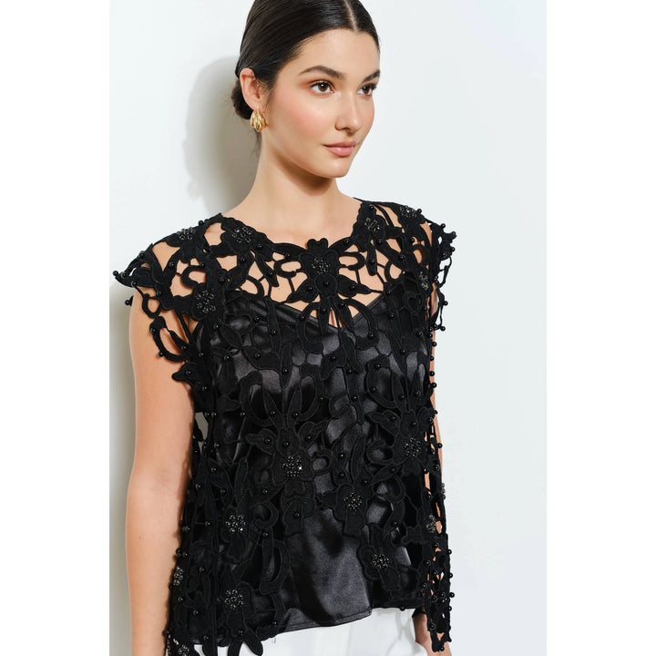 Detail view of black floral lace neckline with pearl and rhinestone embellishments