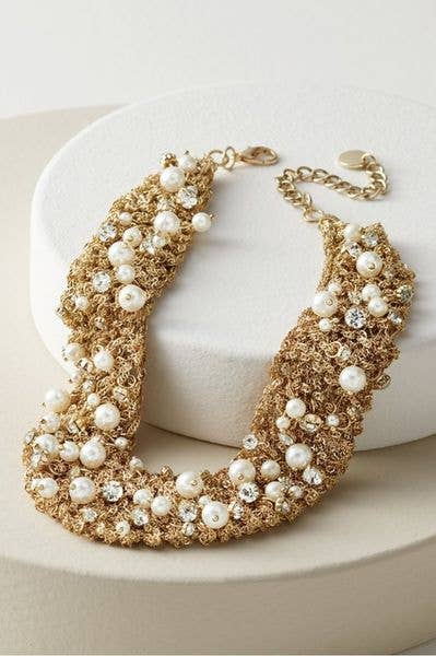 Close-up of SAACHI gold hand-crocheted necklace with pearl and crystal embellishments