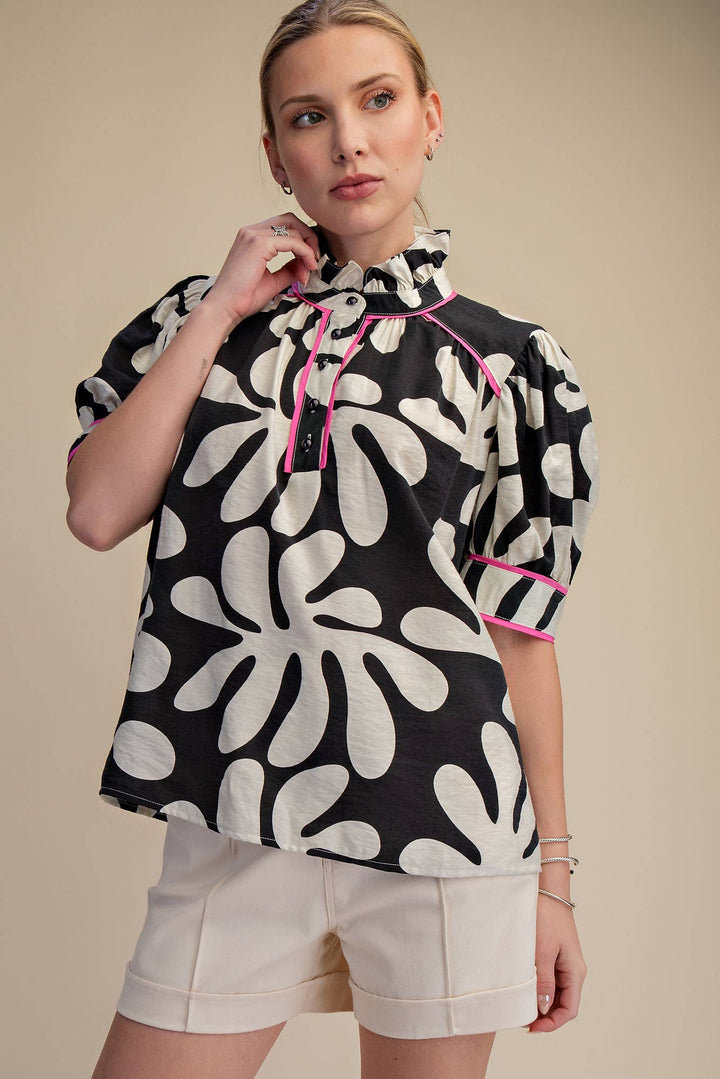 Black and ivory floral print blouse with pink contrast trim, ruffle neck and puff sleeves, relaxed fit front view