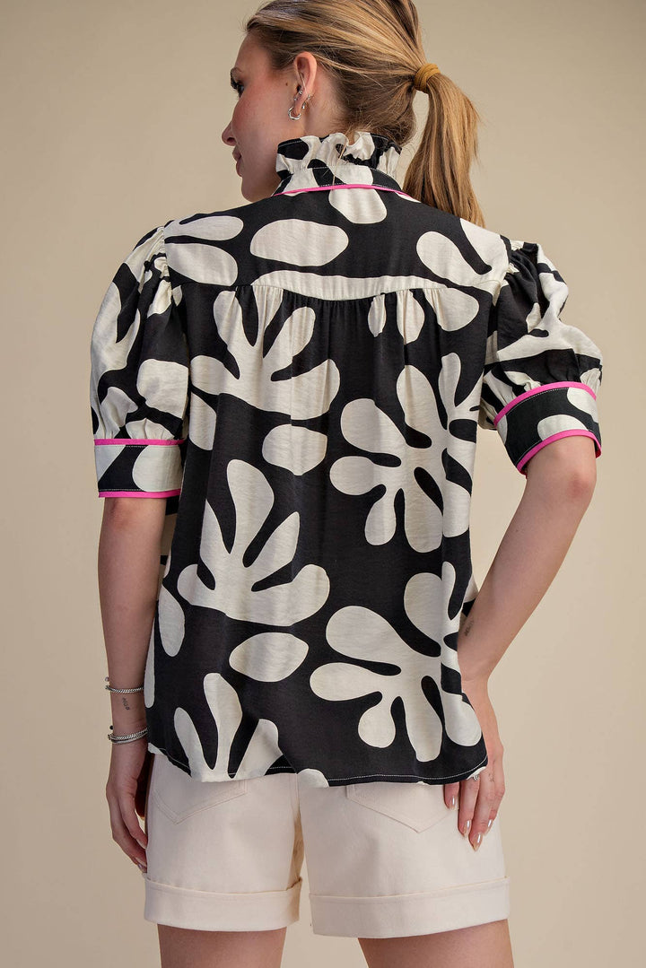 Back view of black and ivory abstract floral blouse with pink piping, puff sleeves and relaxed silhouette