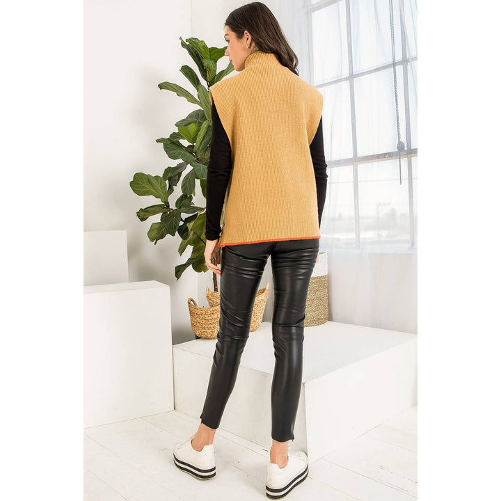 Back view of camel mock neck sweater vest showing relaxed silhouette and orange contrast trim.