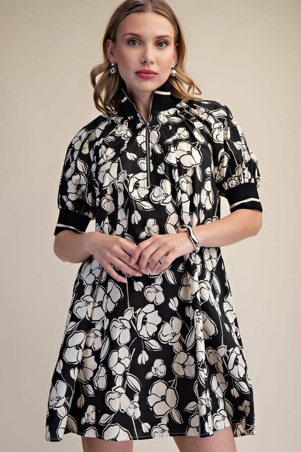 Black and ivory floral A-line mini dress with puff sleeves, striped contrast trim and quarter-zip neckline