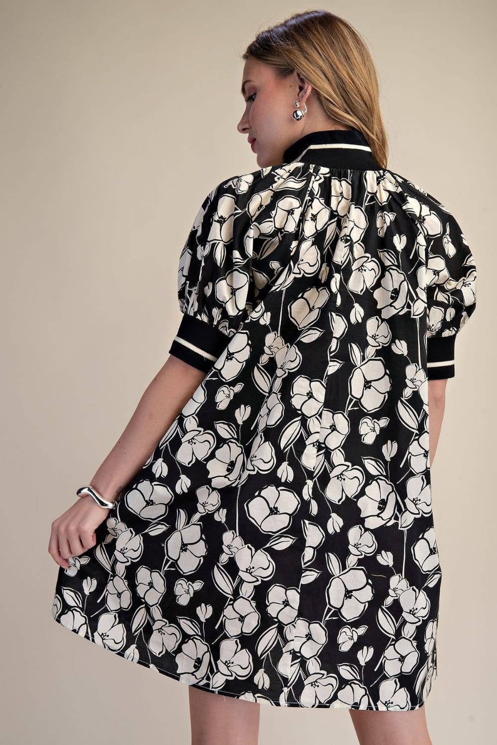 Back view of black and ivory floral mini dress with contrast banded collar, puff sleeves and relaxed A-line fit