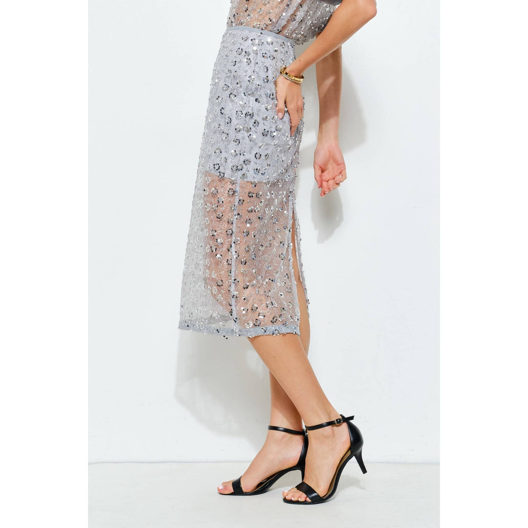 Side view of slate blue floral sequin mesh midi skirt showing sheer panel and back slit