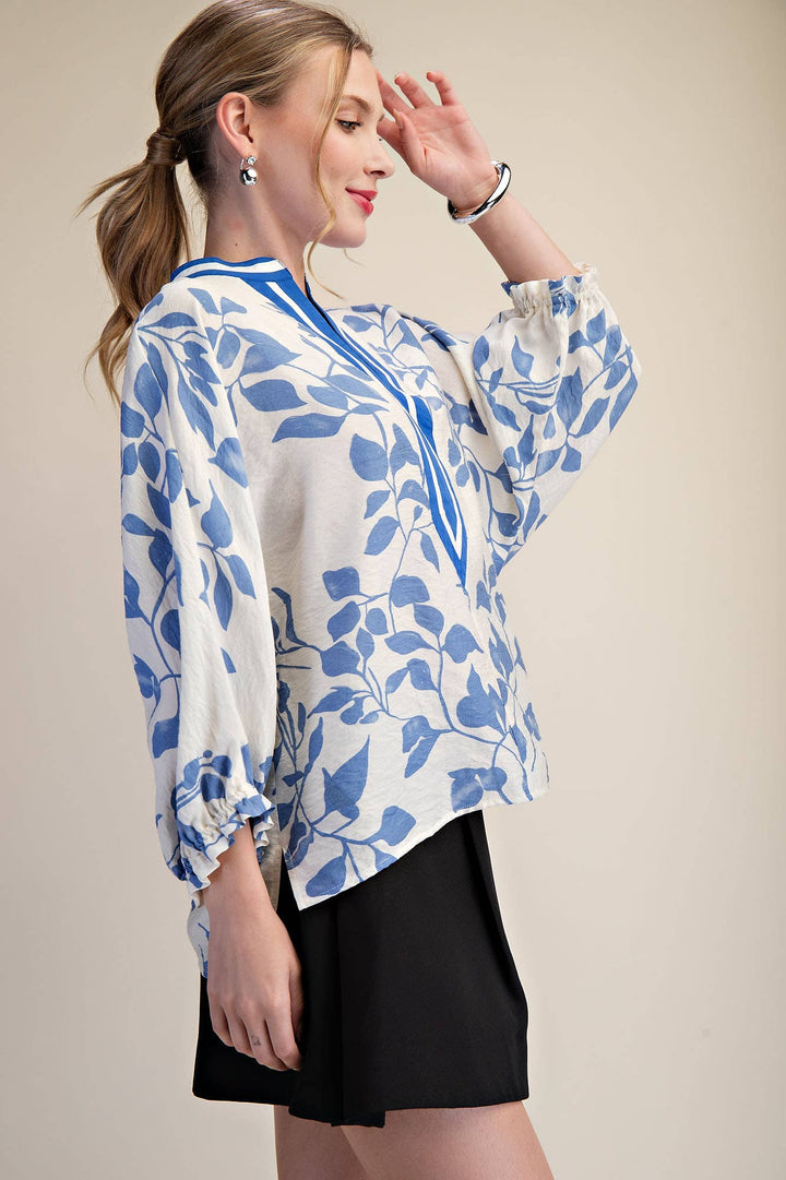 Side view of blue and ivory botanical blouse showing relaxed fit, side slit and ruffled cuff