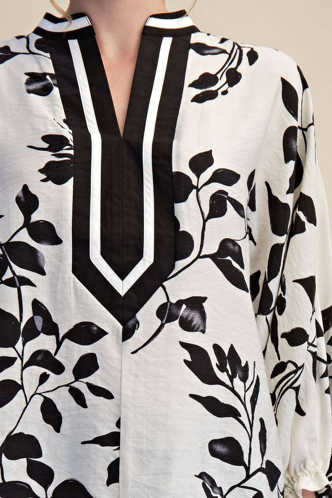 Close-up of Ink & Ivory blouse showing graphic black and white V-neck placket trim
