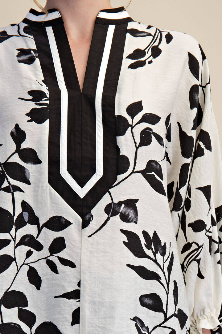 Close-up of Ink & Ivory blouse showing graphic black and white V-neck placket trim