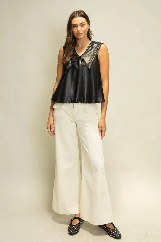 Rebel Romance black faux leather sleeveless top with oversized sailor collar and tie front, styled with ivory wide leg pants.