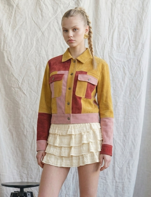 Retro Revival suede jacket showing the multicolor patchwork design, contrast chest pockets, pointed collar and button closure.