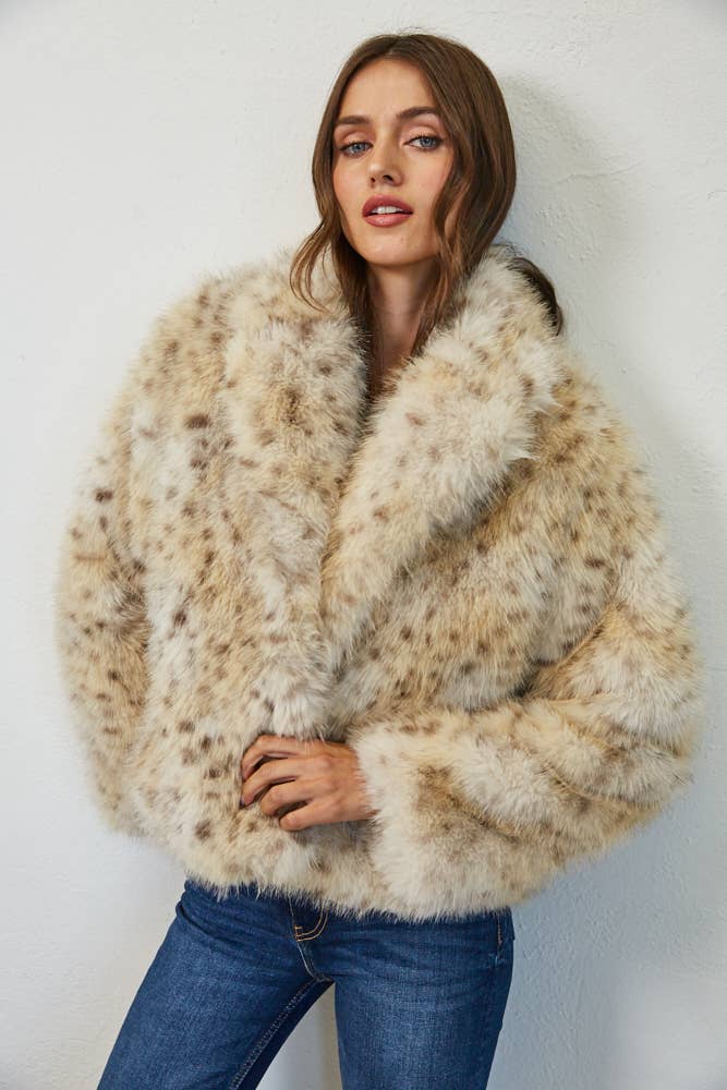 Cream spotted faux fur coat styled with blue denim, showing the plush texture and statement collar.