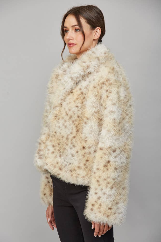 Side view of cream spotted faux fur coat showing relaxed silhouette, long sleeves and cropped length.