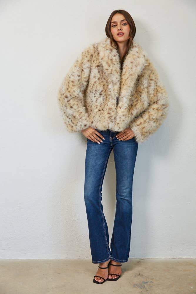 Full-length view of Wild Intentions faux fur coat styled with blue jeans and black heels.