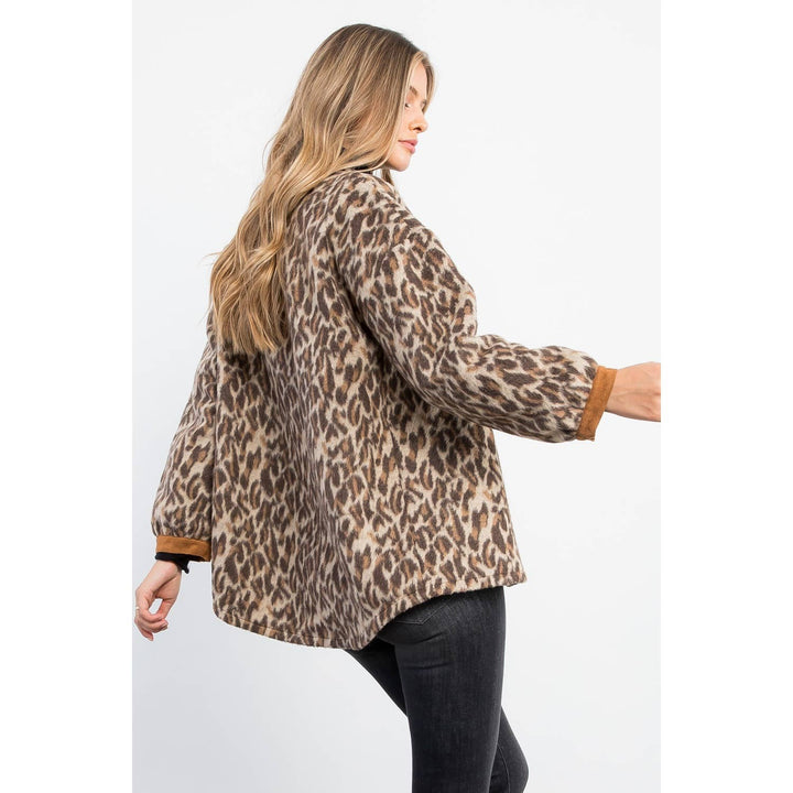 Back view of leopard print jacket showing relaxed fit, curved hem and camel contrast cuffs.