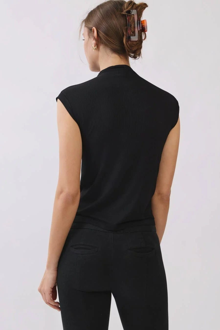 Back view of women's black ribbed mock neck top showing the high neckline and sleeveless design.