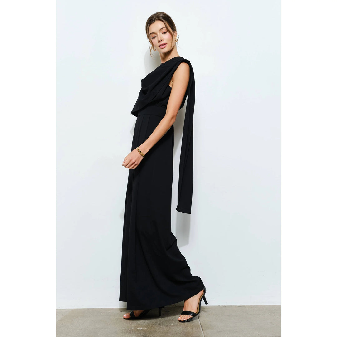 Side view of black wide-leg jumpsuit showing long cascading scarf detail and sleeveless silhouette