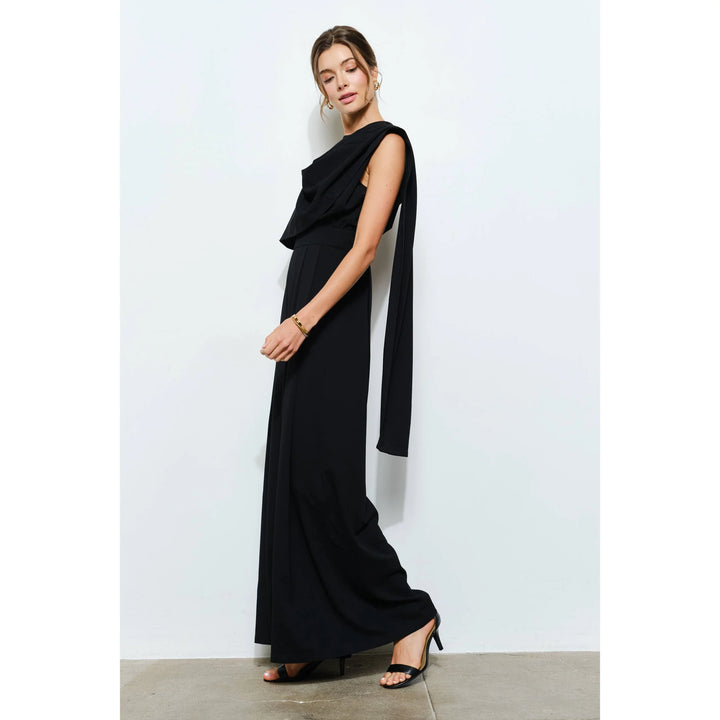 Side view of black wide-leg jumpsuit showing long cascading scarf detail and sleeveless silhouette