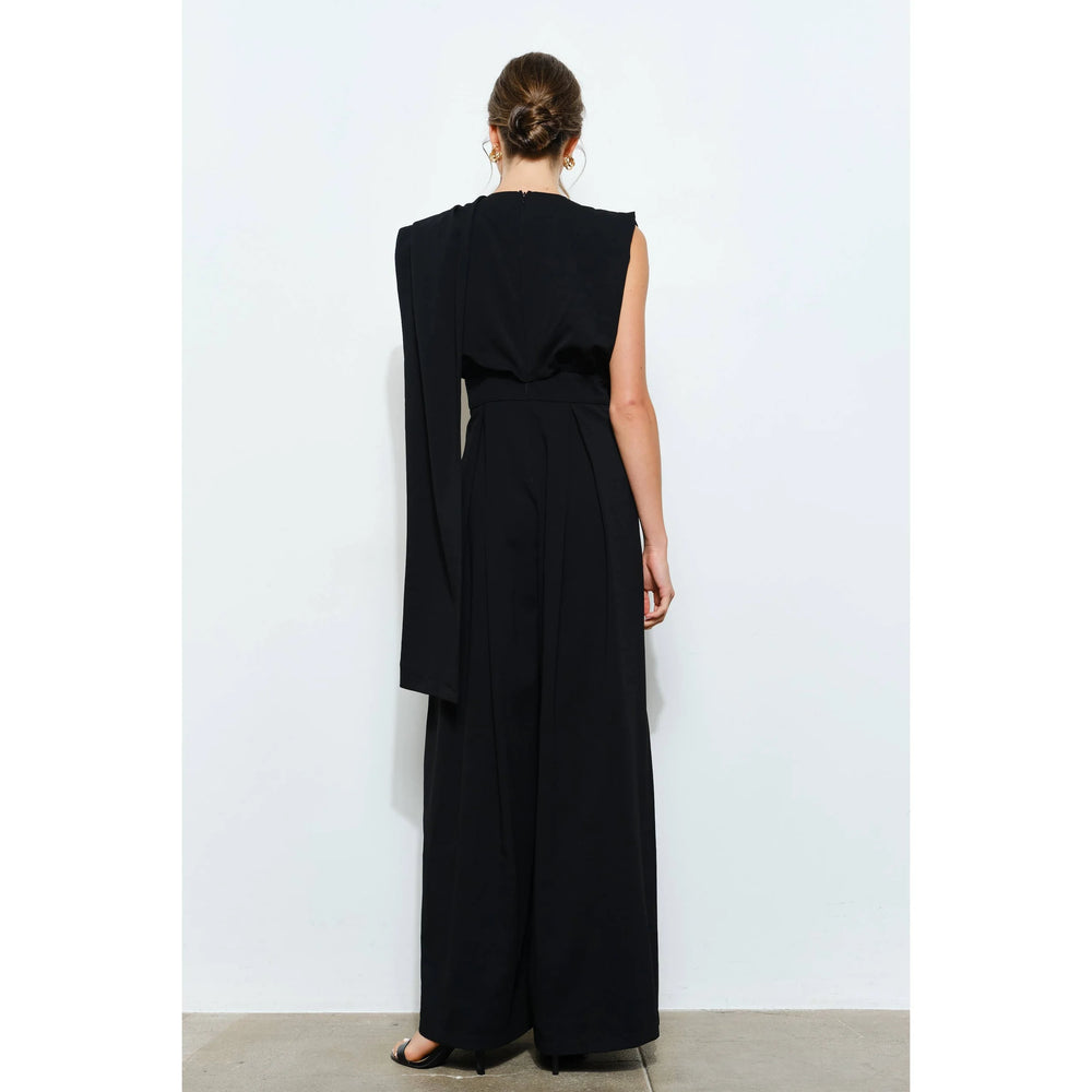 Back view of women’s black jumpsuit with wide-leg pants, defined waist and long draped scarf detail