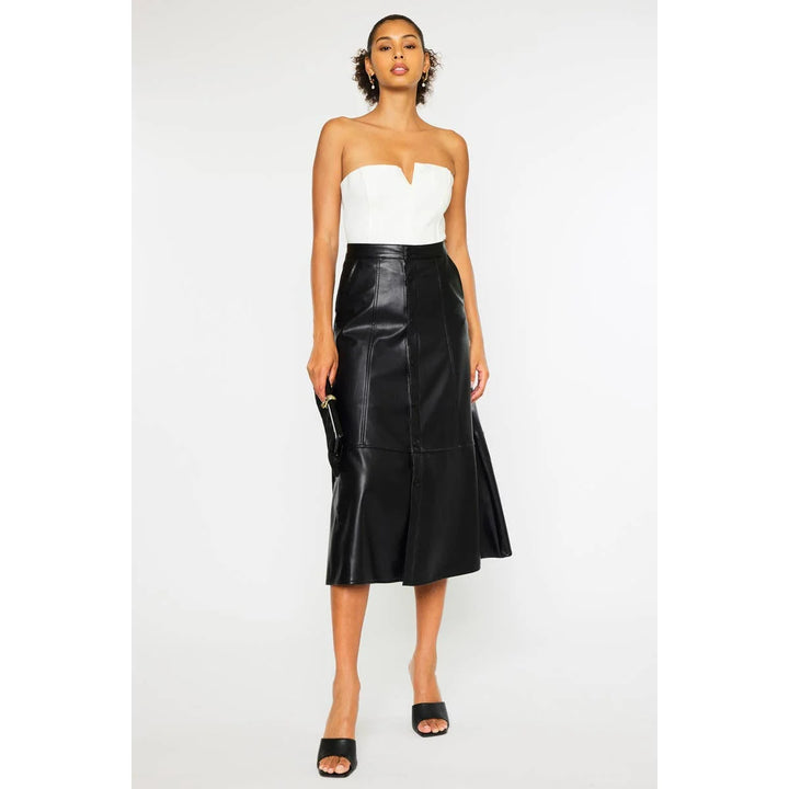 Rebel Luxe black faux leather midi skirt styled with a white strapless top, showing the high-rise A-line silhouette