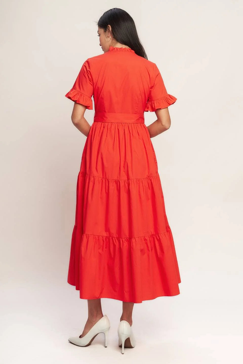 Back view of orange red tiered midi dress with ruffle sleeves and full skirt