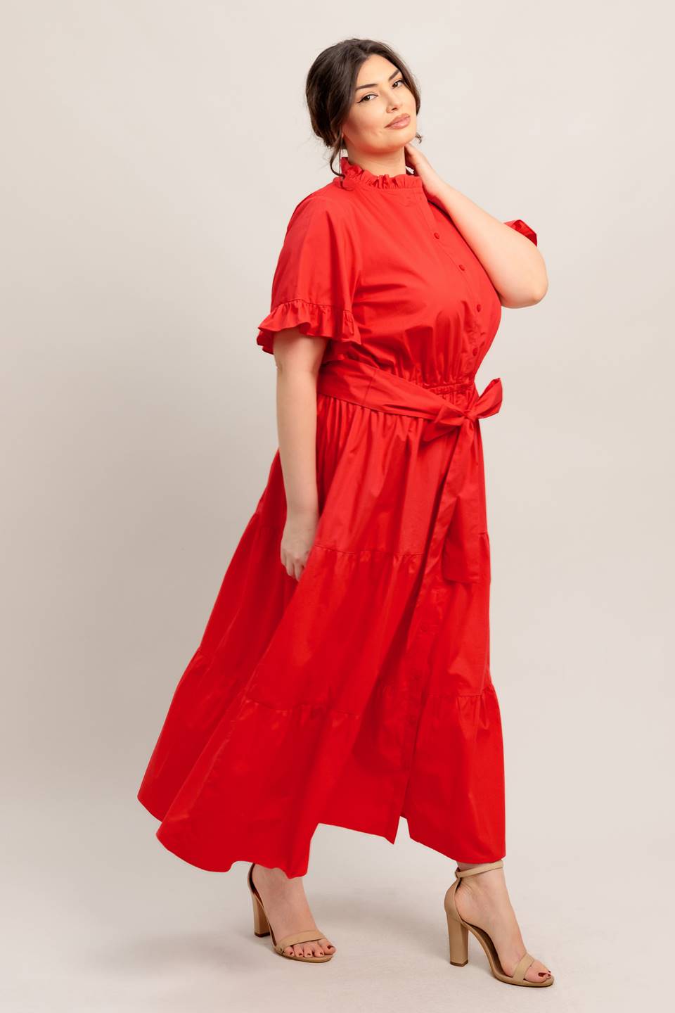 Plus size orange red tiered midi dress shown in three quarter view