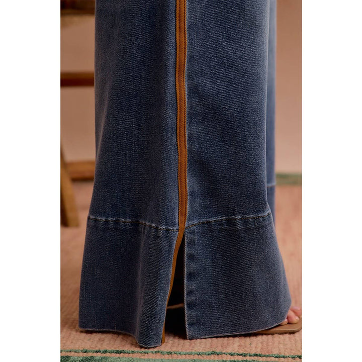 Close-up of cognac side stripe and slit hem detail on wide leg denim jeans